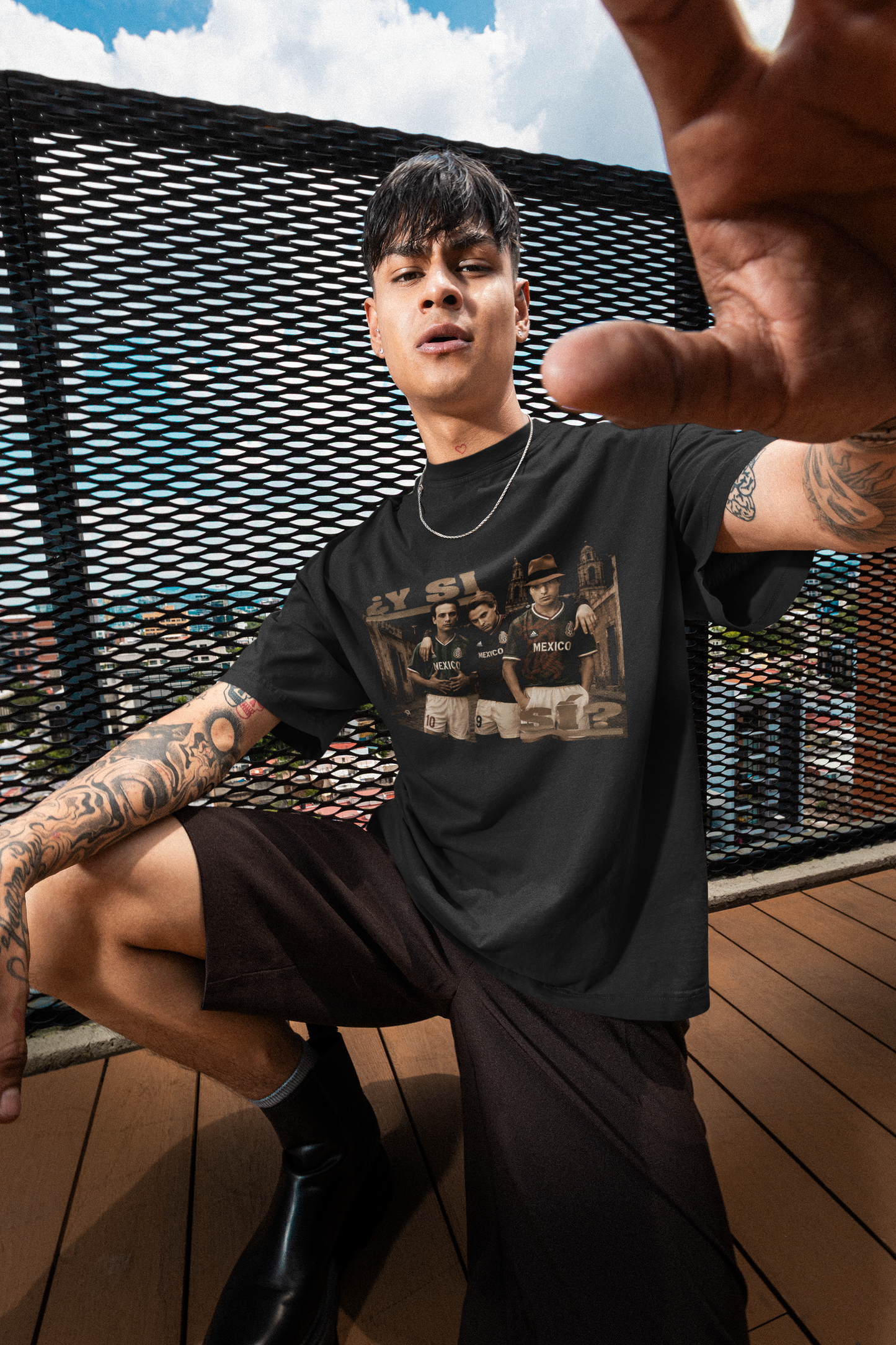 ¿Y SI SI? Mexico World Cup Tee - tattooed man posing on balcony wearing oversized tee